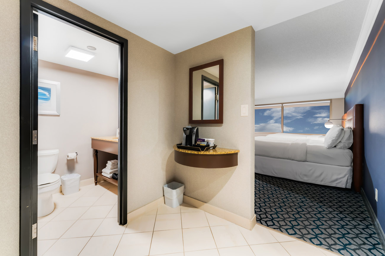 A well-appointed hotel room with a neatly made bed and a private bathroom, designed for relaxation and comfort.
